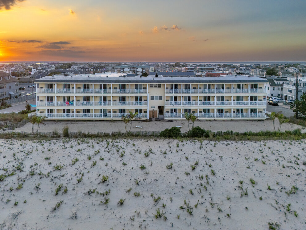 a building with many balconies and a sandy area
