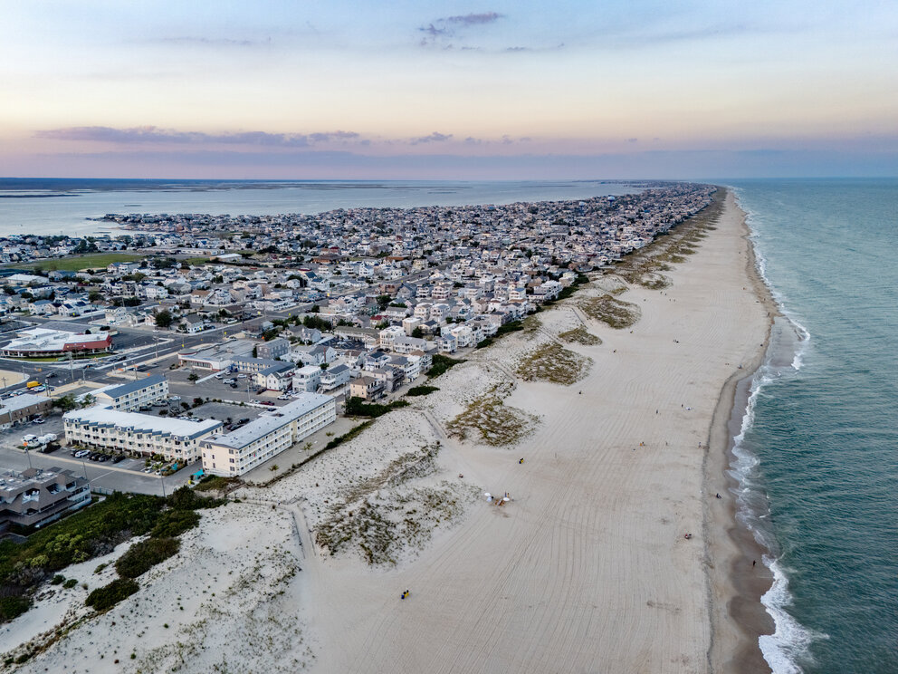 a beach with buildings and a body of water