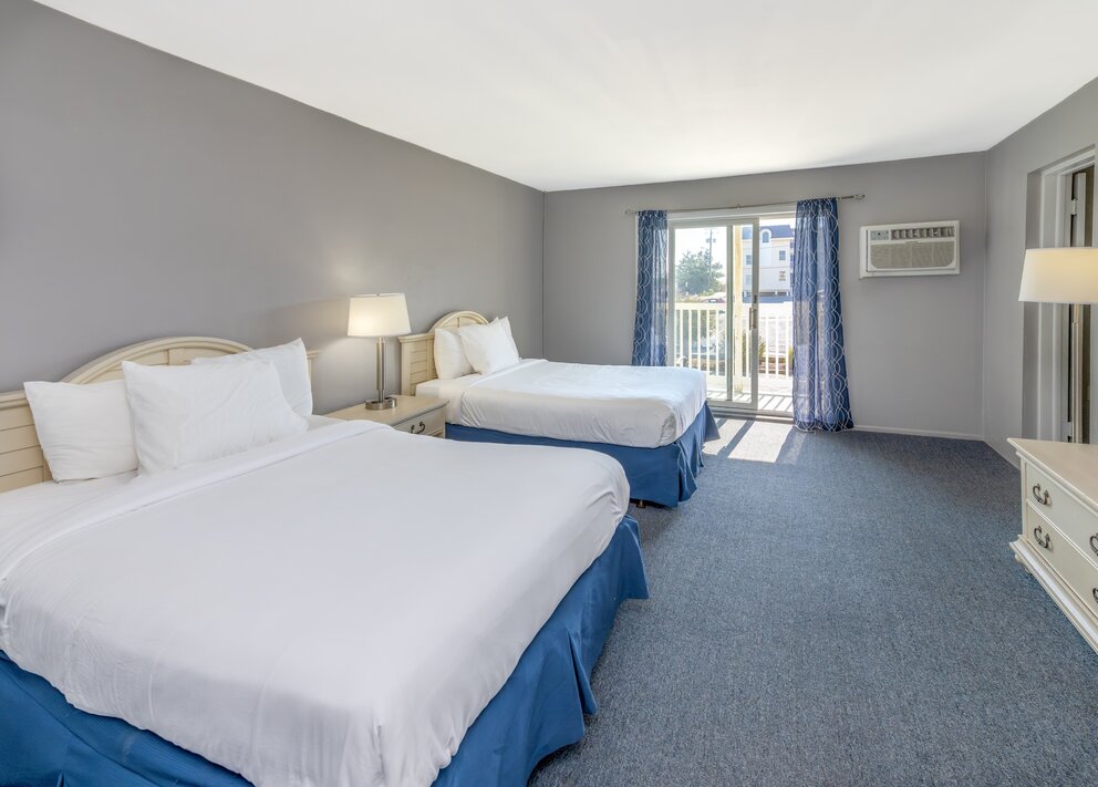 a room with two beds and a balcony