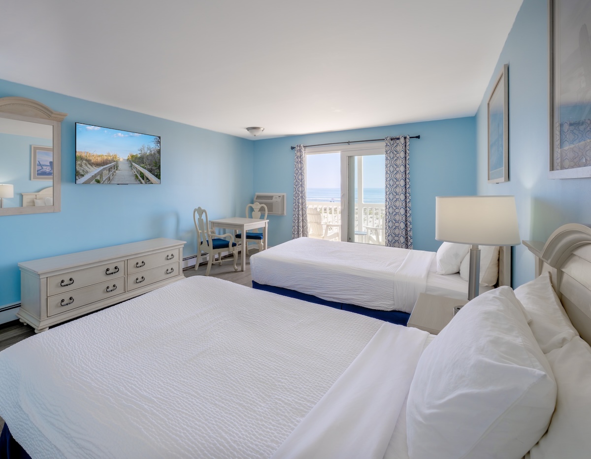 a room with two beds and a table and chairs